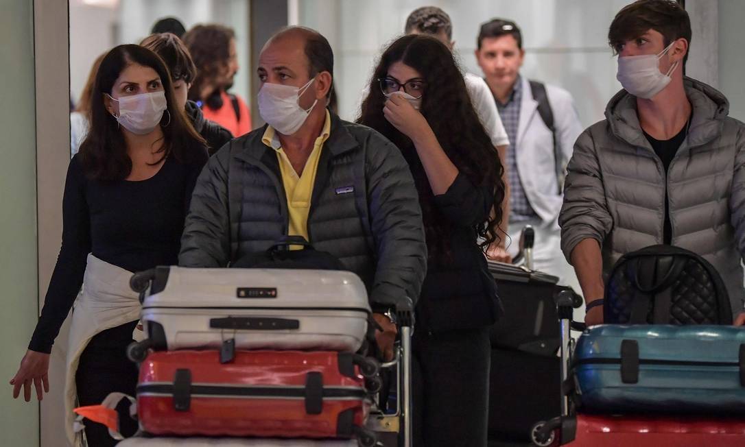 Passageiros com máscara no Aeroporto de Guarulhos, em São Paulo Foto: NELSON ALMEIDA / AFP